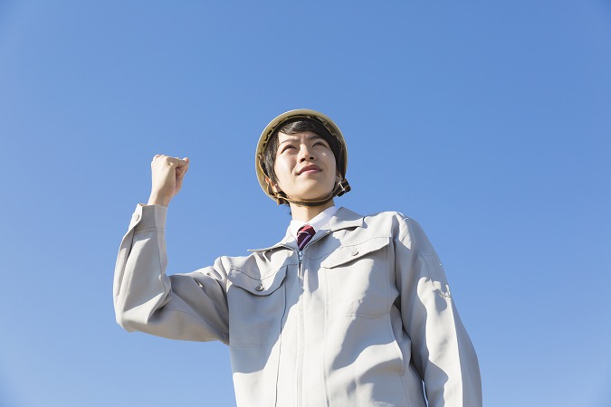 空とガッツポーズの男性