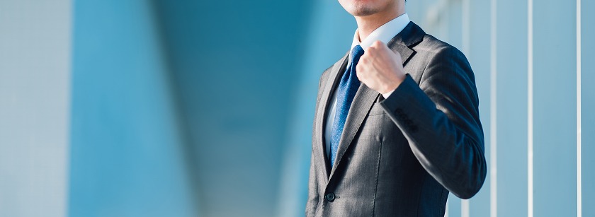 ガッツポーズするスーツ男性