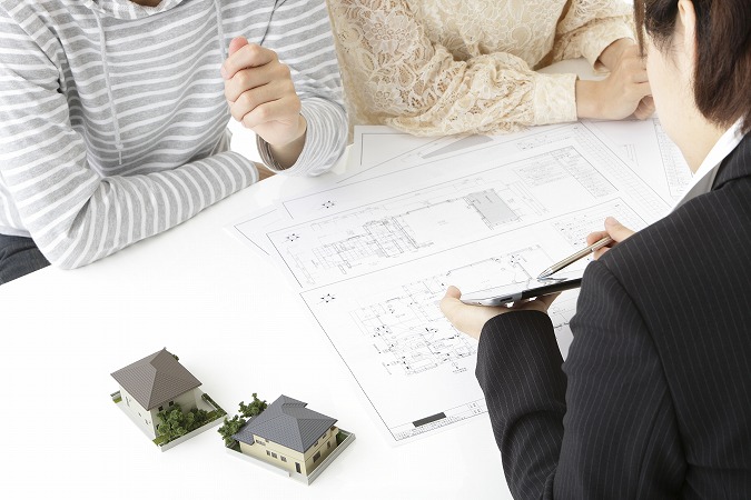 電卓を見せて説明する人